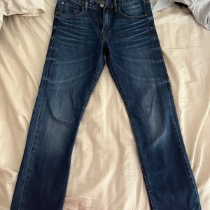 Mörkblå jeansbyxor med raka ben - Snygga mörkblå jeansbyxor i klassisk modell med raka ben och normal passform. Byxorna är i barnstorlek för killar och har tillhört min lillebror men har nu blivit för små för honom, därav säljer vi dom! Lappen är tyvärr avklippt!