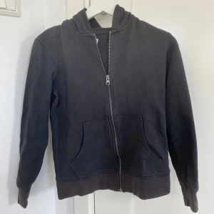 Svart hoodie med dragkedja från Jack & Jones - Säljer en svart hoodie från Jack & Jones i storlek 152. Tröjan har dragkedja framtill, två fickor och huva. Perfekt för en avslappnad stil och enkel att matcha med det mesta. Köpt pris 299kr 84 kr riktigt bra pris 