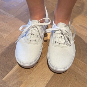 Vita sneakers från Vans - Säljer ett par oanvända klassiska vita sneakers från Vans. Orginal priset var runt 600kr. Perfekta för en stilren och enkel look. Säljer eftersom de är förstora för mig.
