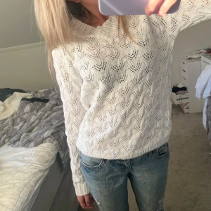 Vit stickad tröja från Isolde - Säljer en vit stickad tröja från Isolde med vackert spetsmönster. Tröjan har lång ärm och en lite bredare ribbad krage. Perfekt att styla med jeans för en fräsch look.