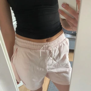 Ljusrosa mjukisshorts med dragsko - Säljer ett par ljusrosa mjukisshorts från Nike. Shortsen har sidofickor