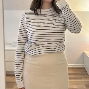 Randig långärmad tröja från Zara - Säljer en klassisk vit långärmad tröja från Zara med tunna svarta horisontella ränder. Tröjan har rund halsringning. 