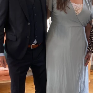 Ljusblå  långklänning  - Säljer en ljusblå långklänning med omlottliv och v-ringning. Klänningen har korta ärmar och en urringningen. Perfekt för sommarens tillställningar! Passar strl 46-52 då den är omlott!