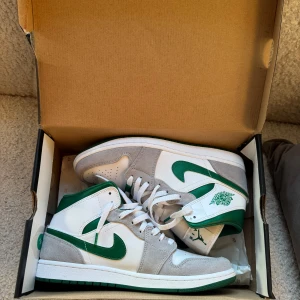 Nike Air Jordans Mid Grey/Green - Säljer ett par Nike Air Jordans Mid då dem bara ligger i lådan, storlek 44, knappt använda så nästintill nya, köpa på merchsweden för något år sedan, kvitto har jag på mail, 800kr snabb och smidig affär 