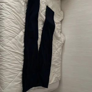 Mörkblå chinos från Jack & Jones - Snygga mörkblå chinos från Jack & Jones med klassisk passform. Byxorna har dragkedjegylf och två bakfickor med dragkedja. Perfekta för en stilren look och passar till många tillfällen.Storelk är 164