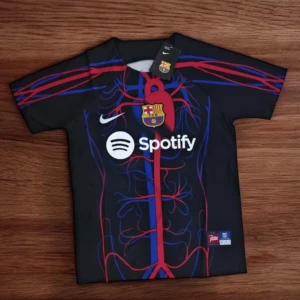 FC Barcelona x Nike kortärmad fotbollströja - Säljer en svart FC Barcelona fotbollströja från Nike med Spotify-logga och klubbmärke på bröstet. Tröjan har ett unikt mönster i rött och blått som liknar blodkärl och muskler. Perfekt för dig som vill sticka ut på planen eller läktaren.
