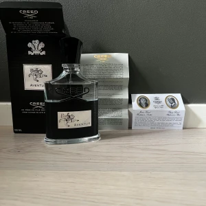 Creed Aventus Eau de Parfum 100ml - Lyxig parfym från Creed, Aventus Eau de Parfum i 100 ml flaska. Flaskan är transparent med svart etikett och silverdetaljer, samt svart kork. Levereras med originalförpackning och informationsblad.