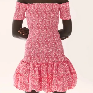 Rosa offshoulder kortklänning med mönster - Söt rosa kortklänning med vitt mönster och offshoulder-modell. Klänningen har ballongkjol nertill och smockad överdel som ger en figurnära passform. Perfekt för sommarens tillfällen! Inte helt säker på om jag vill sälja så måste vara ett bra pris, helst över 800kr💕💕