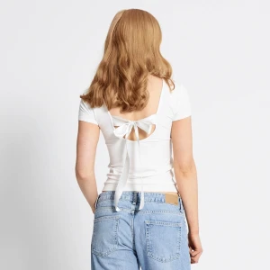 Marta Bow Top från Lager 157 - Marta Bow Top från Lager 157 i färgen vit. Knappt använd och har inga defekter, förutom att snöret har blivit lite mörkare efter tvätt. Köpt för 100 kr. Kontakta mig om ni har några frågor eller vill se fler bilder💕