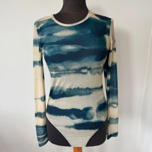 Mönstrad långärmad body  - Trendig långärmad body från Zara med blått och beige abstrakt mönster. Rund halsringning och stor öppen rygg som ger en snygg detalj. Ett stretchigt syntetmaterial för en tight passform. Storlek M och är aldrig använd🩷