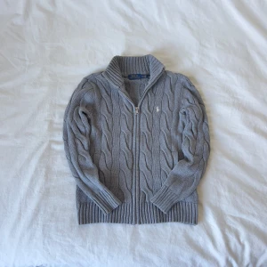 Grå stickad tröja från Polo Ralph Lauren XS - Ralph Lauren Cable Knit – Klassisk kabelstickad tröja i 100% bomull. Perfekt för en tidlös och stilren look. Diskret broderad logga på bröstet. Mjuk, bekväm och i fint skick. Passar både till vardags och mer uppklädda tillfällen.  ✔️ Skickas samma dag eller senast nästa! ✔️ Mätningar finns i bilderna.  Hör av dig vid frågor!  #RalphLauren #RalphLaurenStyle #RalphLaurenFashion #RalphLaurenCollection #RalphLaurenLife #RalphLaurenLovers #RalphLaurenInspiration #RalphLaurenOutfit #RalphLaurenVibes #Ra