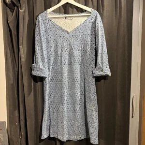 Blå och vit klänning från eBETH'S - Snygg blå och vit klänning med geometriskt mönster från eBETH'S. Klänningen har trekvartsärmar med knappar och en v-ringad hals. Skriv gärna om eventuella frågor.💙