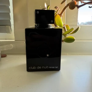 Club de Nuit Intense Man Parfym 100ml - Säljer en elegant och maskulin parfym från Armaf, Club de Nuit Intense Man. Flaskan är stilrent svart med en fyrkantig design och en matchande svart kork. Perfekt för den som vill ha en intensiv och långvarig doft. 100ml flaska, ca 95ml kvar , nypris 600kr 
