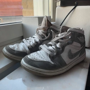 Nike Air Jordans i grått och vitt - Säljer ett par klassiska Nike Air Jordans i grått och vitt. Skorna har en snygg design med snörning och den ikoniska Air Jordan-loggan på sidan. Äkta, kvitto och låda finns.  Stl 36.5-37