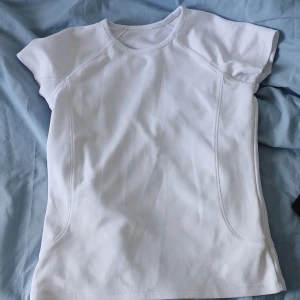 Vit kortärmad t-shirt - Säljer en enkel och stilren vit t-shirt med korta ärmar. Perfekt för en avslappnad look. T-shirten har en rund halsringning och är gjord i ett mjukt material.