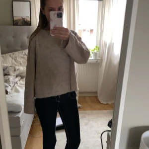 Beige stickad tröja - Säljer en mysig beige stickad tröja med långa ärmar. Perfekt för kyliga dagar och har en enkel, stilren design. 