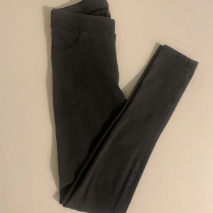 Grå jeansleggings - Snygga grå jeansleggings med en tight passform. De har en elastisk midja och ser ut som jeans med fickdetaljer. Perfekta för en stilren look.