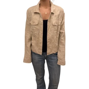 Beige jacka från Quince - Selling a stylish beige jacket from Quince in size S. The jacket has long sleeves and buttons at the front as well as two chest pockets with flaps. Perfect for a casual look