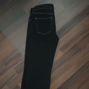 Svarta jeans med vita sömmar - Snygga svarta jeans med vita sömmar från Nelly.  Rak design, säljer då de inte används! 