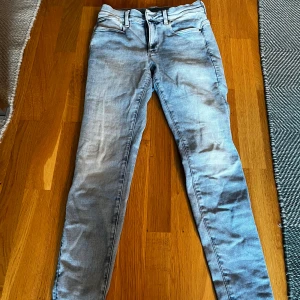 Ljusblå jeans från G-Star RAW - Snygga ljusblå jeans från G-Star RAW med en klassisk femficksdesign. De har en slim passform och är perfekta för en avslappnad stil. Jeansen har en dragkedja och knapp framtill.