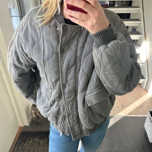 Grå bomberjacka - Säljer den fina gråa jackan från Zara. Jackan har både knappar och dragkedja. Den är använd väldigt få gånger så den är i ett mycket bra skick. 