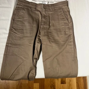 Beige chinos med dragkedja - Snygga beige chinos med dragkedja. De har en normal passform och är perfekta för en stilren look. Tillverkade i ett bekvämt bomullsmaterial.Storlek 30/32