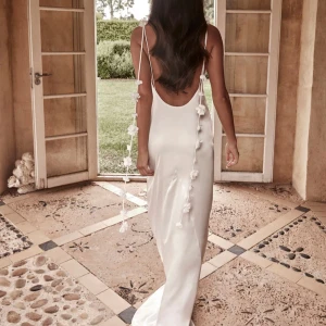 Vit långklänning med blommiga detaljer - Intressekoll på denna vita långklänning med blommiga detaljer. Prislappen kvar och nypris 1600kr! 