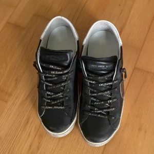 Svarta sneakers från Philippe Model - Snygga svarta sneakers från Philippe Model med vita detaljer och snörning. Skorna har en klassisk design med en brun sula och är perfekta för en stilren look. De kommer med originalförpackning och påse, se bild 4. Storlek 40. Har inte mycket tecken på användning. Pris kan diskuteras. Skriv om ni har någon fråga.😄