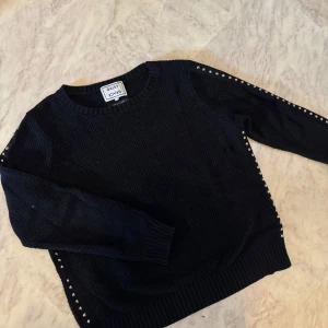 Svart stickad tröja från Daisy Grace - Svart stickad tröja från Daisy Grace storlek M. Tyvärr har det lossnat 4 nitar, se sista bilden. Men ingen som är märkbart.