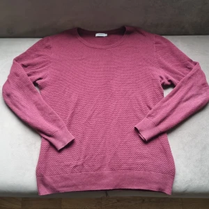 Vinröd tröja från J.Lindeberg - Säljer en stilren vinröd tröja från J.Lindeberg. Tröjan har en texturerad yta och långa ärmar med ribbade muddar. Perfekt för en avslappnad men snygg look. Nypris: 699. Sitter mer som än L istället för XL. 