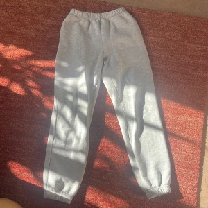 Grå mjukisbyxor från Gina Tricot - Säljer ett par grå mjukisbyxor från Gina Tricot. De har en elastisk midja och muddar vid bensluten för en bekväm passform. Perfekta för en avslappnad stil. Storlek Xs. Bra skick 