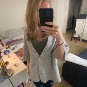 Ginatricot  - En mysig grå trekvartsärmad kofta med knappar 