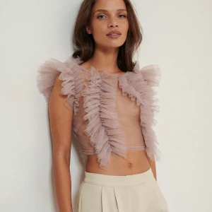 Tyllblus  - Säljer en elegant ljus rosa blus med volangdetaljer från NA-KD ART. Storlek 36, endast använd en gång💗