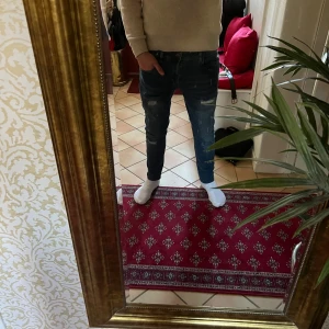 Blåa jeans med slitningar från indicode  - Snygga blå jeans med slitningar på låren och knäna. De har en modern och tight passform som sitter bra. Perfekta för en avslappnad stil.34-32 storlek 