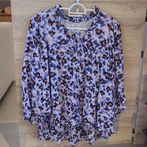 Blommig blus - Tunn skön blommig blus från Noa Noa i stlk 42/L. Luftigt material perfekt för sommaren och lila blommig design. Snöre och knapp framtill och rush vid nacken. Nypris ca 700kr, knappt använd.