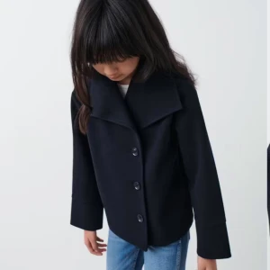 Marinblå kappa  - Snygg marinblå kappa med stora knappar framtill och en stilren design. Jackan har en klassisk krage och långa ärmar, perfekt för en elegant look. Passar bra till både jeans och mer uppklädda outfits. Från Gina Young i storlek 146-152 men passar xxs-xs