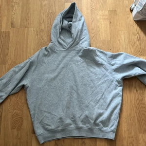 Grå hoodie från Arket - Säljer en klassisk grå hoodie i storlek M. Den är tillverkad i ett mjukt material och har en bekväm passform med långa ärmar och en praktisk huva. Perfekt för en avslappnad stil.