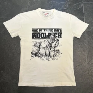 Vit t-shirt från Woolrich - Säljer en vit t-shirt från Woolrich med ett fett tryck som är perfekt till sommaren. Kvaliteten på tröjan är galet bra och den är bara använd fåtal gånger. 