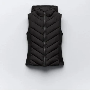 Svart Zara väst - Säljer denna jättefina och populära Zara västen i mycket bra skick! Den har både dragkedja och luva. Det finns även två fickor med dragkedja på vardera sida💓