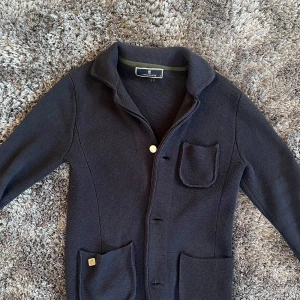 Hansen & Jacob tröja - Säljer min blåa Hansen & Jacob cardigan/tröja. Jättebra skick, nästan oanvänd. Går jättebra att vika ner kragen med.