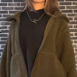 Olivgrön teddyjacka - INTE MIN BILD SKRIV PRIVAT OM NI VILL HA BILD!!!Mysig olivgrön teddyjacka med en avslappnad passform. Perfekt för kyliga dagar med sin mjuka och varma känsla. Jackan har en dragkedja framtill och stora fickor för extra komfort.