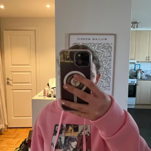 Rosa hoodie med Taylor Swift-tryck - Säljer en rosa hoodie med tryck från Taylor Swift The Eras Tour. Framsidan har ett collage av bilder och text, medan baksidan listar turnéstäder och album. Köpte den men insåg att den var för liten. Helt ny alltså! Perfekt för Swifties!💖