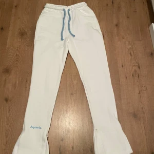 Vita mjukisbyxor med blå detaljer - OBS: hoodien finns även tillgänglig att köpa med, vid köp av hela tracksuiten så blir priset billigare 