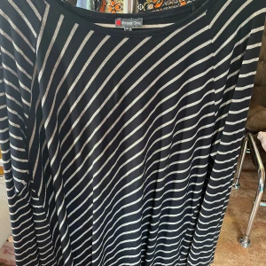 Street One långärmad tvärrandig stl 44 - En elegant långärmad tröja från Street One som har glittriga lätt diagonala ljusa silver linjer mot svart. stl 44