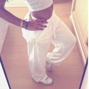 Vita linne byxor - Säljer ett par vita mjukisbyxor med snörning i midjan. Byxorna har en loose passform och är perfekta för en avslappnad stil. De är tillverkade i ett mjukt material som ger en bekväm känsla hela dagen.