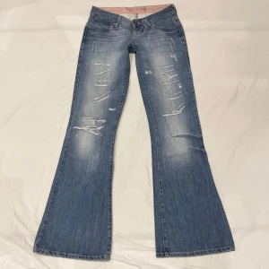 Lågmidjade bootcut jeans med slitningar💕 - Försmå så tar inga bilder på!!!! Midja 37x2 cm, gren 17 cm o innerben 81 cm💕Obs svag rosa fläck på sista bilden. Märkta W27/L32 men försmå för mig som är W25-26 så absolut mer xxs