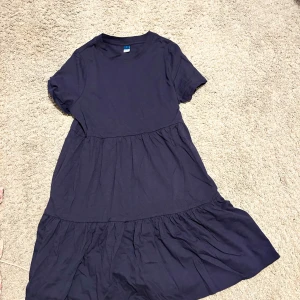 Mörkblå klänning från Old Navy - Säljer en mörkblå klänning från Old Navy i storlek S. Klänningen har korta ärmar och en avslappnad passform med volangdetaljer i kjolen. 
