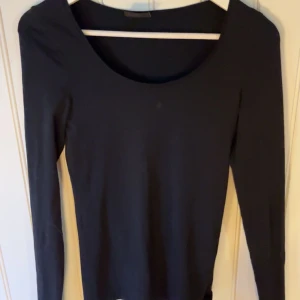 Svart långärmad topp från Vila - Snygg svart långärmad topp från Vila i storlek XS. Perfekt för en stilren look med sin enkla design och mjuka material. Passar bra till både jeans och kjol.