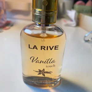 La Rive Vanilla Touch Eau de Parfum - Jag säljer denna flaska, La Rive Vanilla Touch Eau de Parfum. Den har en söt och varm vaniljdoft, perfekt för dig som älskar mjuka och inbjudande dofter. Flaskan rymmer 30 ml och har en elegant design med en gyllene kork. Bara testat den ett fåtal gånger. Kontakta gärna mig om du har frågor eller vill ge ett prisförslag😊