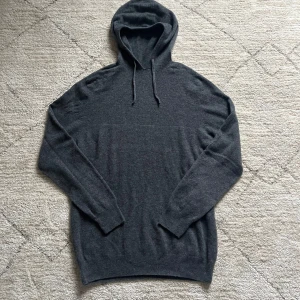 Stickad hoodie - Säljer en stilren stickad hoodie med långa ärmar och justerbar huva. Perfekt för kyliga dagar och passar till det mesta. Skön och enkel design som funkar året runt.